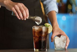 A bartender skillfully prepares a refreshing drink with ice and lime at the Seaside Bar onboard MSC Seaside | MSC Cruises