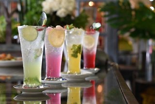 Colourful cocktails are elegantly arranged on a bar counter, showcasing refreshing ingredients like lemon and mint | MSC Cruises