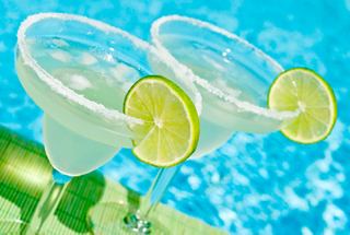 Two refreshing cocktails with lime slices beside a sparkling pool, inviting relaxation and enjoyment | MSC Cruises