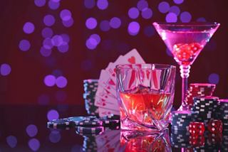 A vibrant cocktail alongside playing cards in an elegant setting, inviting you to enjoy the nightlife on board | MSC Cruises