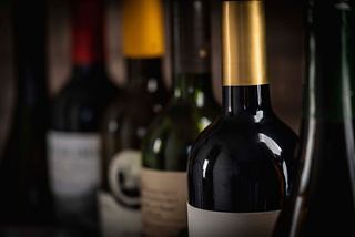 A selection of wine bottles with varying coloured caps displayed in a wine cellar aboard the MSC Seascape | MSC Cruises