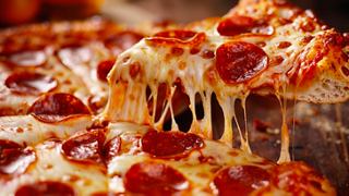 Melted cheese and toppings stretch from a freshly baked pizza slice, inviting a delightful dining experience | MSC Cruises