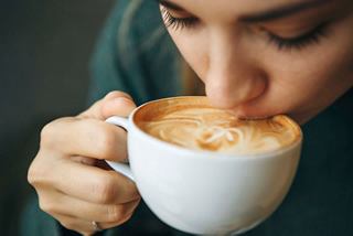 A woman enjoying a cappuccino at a stylish café, embracing a moment of relaxation | MSC Cruises