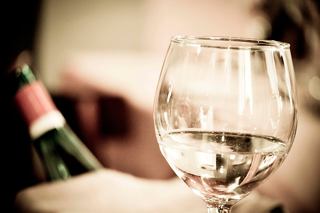 A hand reaches for a glass of refreshing beverage beside a bottle, enhancing the dining experience on MSC Seascape | MSC Cruises