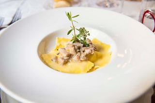 A delicious plate of ravioli garnished with thyme, served in a fine dining setting aboard MSC Seascape | MSC Cruises