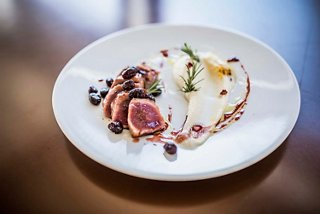 A gourmet dish featuring duck accompanied by vibrant vegetables on a white plate | MSC Cruises