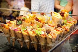 Un vivace banco di mercato pieno di antipasti colorati e burritos, invitando a gustare le delizie culinarie di Barcellona | MSC Crociere