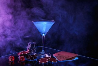A vibrant blue cocktail glass sits elegantly on a table adorned with sweets, inviting relaxation and enjoyment | MSC Cruises