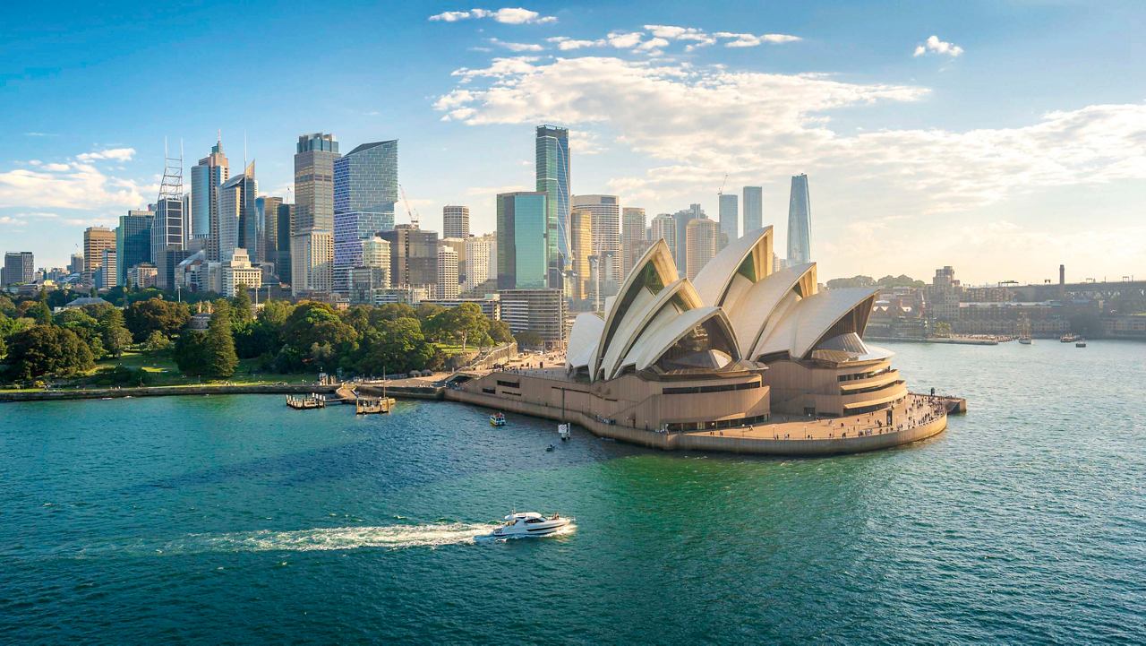 Aerial view of Sydney showcasing the iconic Opera House and city skyline beside the sparkling sea | MSC Cruises