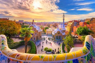 View of Park Güell in Barcelona at sunset, featuring people and vibrant mosaics | MSC Cruises