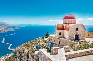 A charming church with a red roof perched on a cliff overlooking the stunning Mediterranean Sea in Corfu, Greece | MSC Cruises