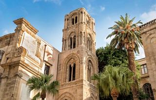 The historic Church of St. Mary of the Admiral in Palermo, framed by lush palm trees and a clear blue sky | MSC Cruises