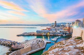 Une vue pittoresque de la côte au coucher du soleil, avec des bateaux et des rivages rocheux à Marseille, France | MSC Croisières