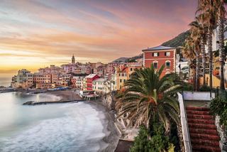 Una vista costiera pittoresca di case colorate al tramonto a Genova, Italia, affacciata sul sereno Mar Mediterraneo | MSC Crociere