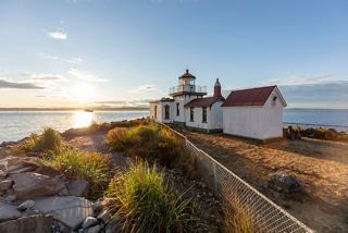 Un faro en la costa de Alaska iluminado por el sol, con el mar de fondo | MSC Cruceros