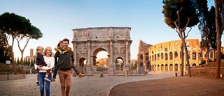 Dos personas están juntas frente al Arco de Constantino al atardecer en Roma, Italia | MSC Cruceros
