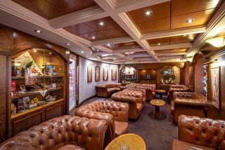 A warm and inviting lounge area with leather sofas and tables, perfect for relaxation and socialising | MSC Cruises