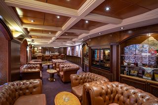 A warm and inviting lounge area featuring plush seating and a stylish bar counter for relaxation | MSC Cruises