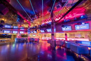 A vibrant dance floor illuminated by colourful lights, creating an inviting atmosphere for entertainment on MSC Orchestra | MSC Cruises