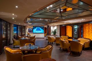 A stylish lounge area with comfortable seating and a large screen, perfect for relaxation and entertainment | MSC Cruises
