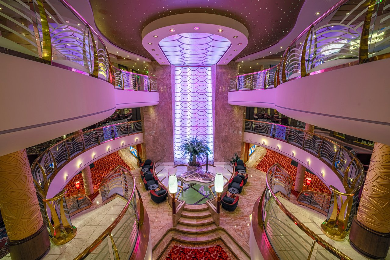 A stylish reception area with elegant seating, vibrant lighting, and welcoming decor on the MSC Orchestra | MSC Cruises