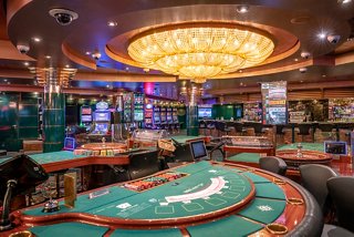 A vibrant casino area featuring gaming tables, slot machines, and a luxurious atmosphere on MSC Orchestra | MSC Cruises