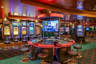Exciting scene of the Palm Beach Casino with vibrant slot machines inviting guests to enjoy entertainment on board | MSC Cruises