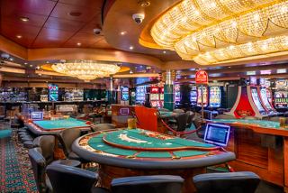 A vibrant casino area featuring gaming tables and slot machines, perfect for entertainment aboard MSC Orchestra | MSC Cruises