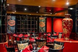 A vibrant dining area featuring red decor and elegant seating in a speciality restaurant onboard MSC Orchestra | MSC Cruises