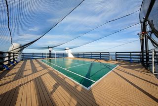A serene pool area with wooden decking overlooking the sea, inviting relaxation and leisure activities | MSC Cruises
