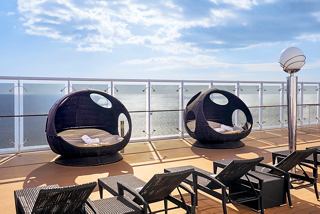 Sillas de sol relajantes en un sereno solárium con vistas al mar, invitando a los huéspedes a relajarse y disfrutar de la atmósfera tranquila | MSC Cruceros