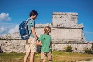 Un père et son fils explorent les ruines de Tulum, partageant un moment d'émerveillement et de découverte ensemble | MSC Croisières