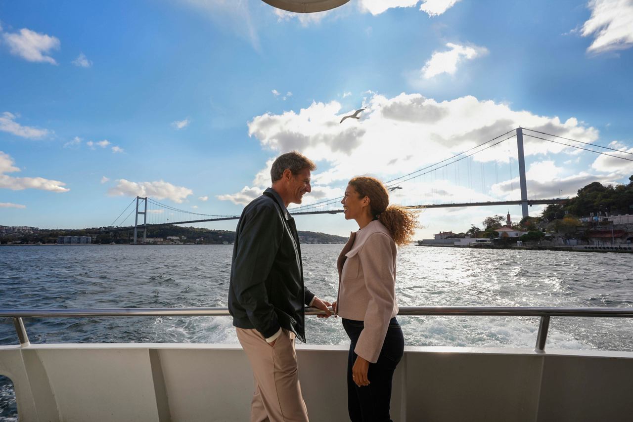 A couple enjoys a moment together on a Bosphorus cruise in Istanbul, with a scenic bridge in the background | MSC Cruises