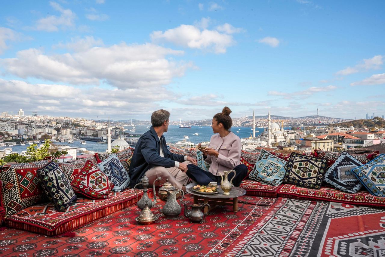 A couple enjoys tea and pastries while overlooking the Bosphorus from a rooftop café in Istanbul | MSC Cruises