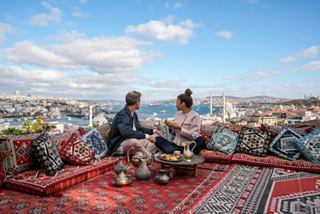 A couple enjoys tea and pastries while overlooking the Bosphorus from a rooftop café in Istanbul | MSC Cruises