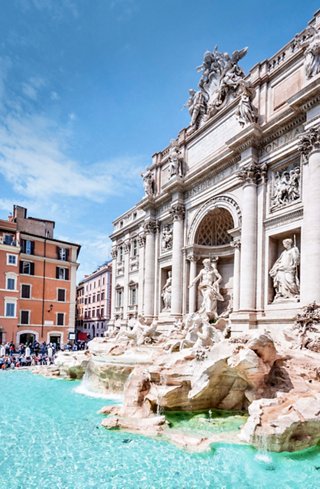 The Trevi Fountain in Rome, surrounded by magnificent architecture and clear blue water | MSC Cruises