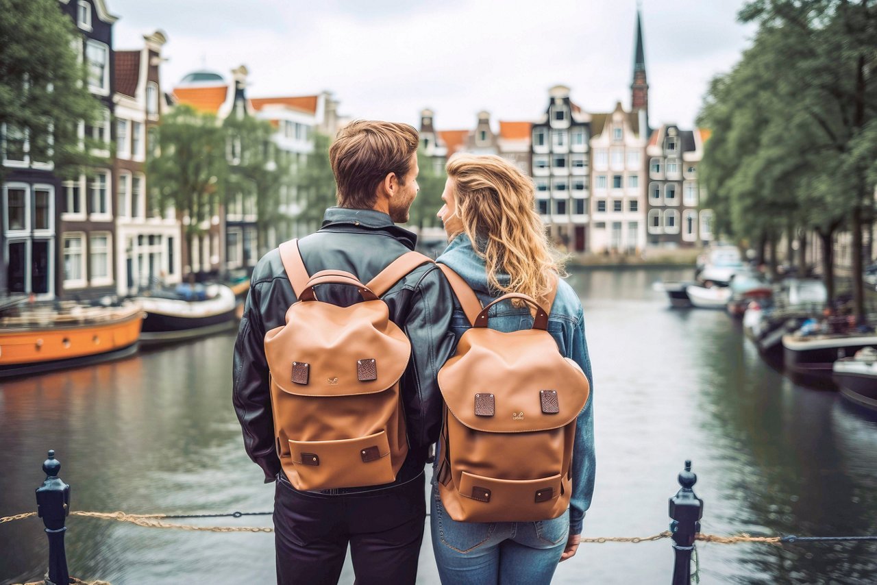 Un couple se tient ensemble près d'un canal à Amsterdam, profitant de la vue pittoresque sur les bâtiments et les environs vibrants | MSC Croisières