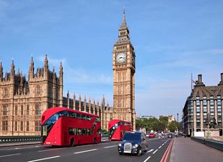 Rote Doppeldeckerbusse fahren an Big Ben in London vorbei und zeigen die ikonische Architektur der Stadt | MSC Cruises