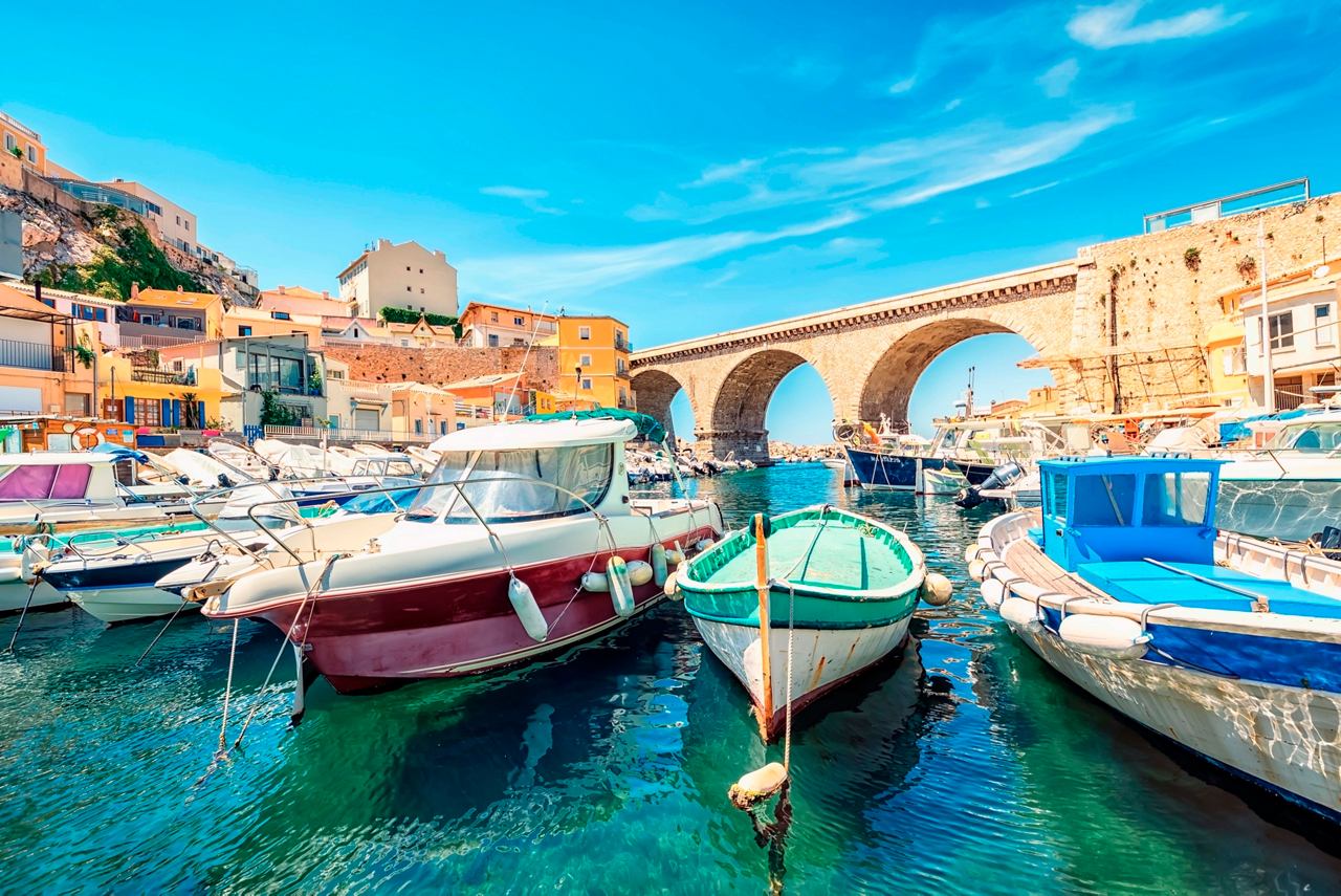 Vibrant marina with boats and an arch, showcasing the beauty of Marseille's Mediterranean charm | MSC Cruises