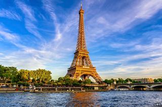 The Eiffel Tower stands majestically by the River Seine against a vibrant sky | MSC Cruises