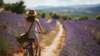 A woman rides a bicycle along a lavender field path in Provence, France, surrounded by stunning Mediterranean nature | MSC Cruises
