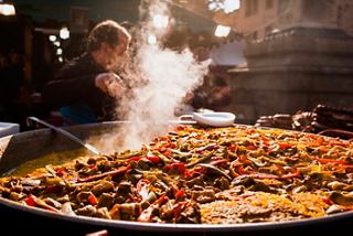 Une paella vibrante est préparée dans un cadre animé, mettant en valeur la tradition culinaire de Valence | MSC Croisières