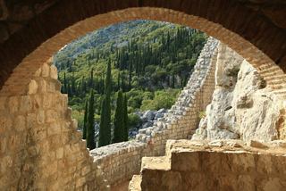 Ein Blick durch einen Bogen auf üppige Bäume und malerische Landschaften in Dubrovnik, Kroatien | MSC Cruises