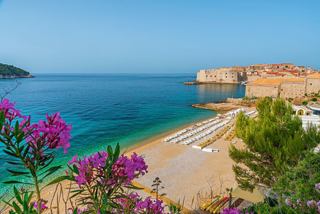 Eine ruhige Aussicht auf den Banje-Strand in Dubrovnik, umrahmt von lebhaften Blumen und historischer Architektur am Meer | MSC Cruises