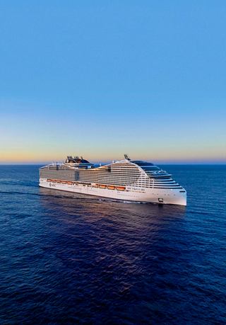 Aerial view of the MSC World Asia sailing on calm seas under a beautiful sunset sky | MSC Cruises