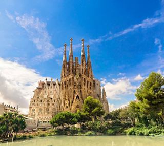La impresionante Sagrada Familia en Barcelona, rodeada de vegetación y un cielo azul | MSC Cruceros