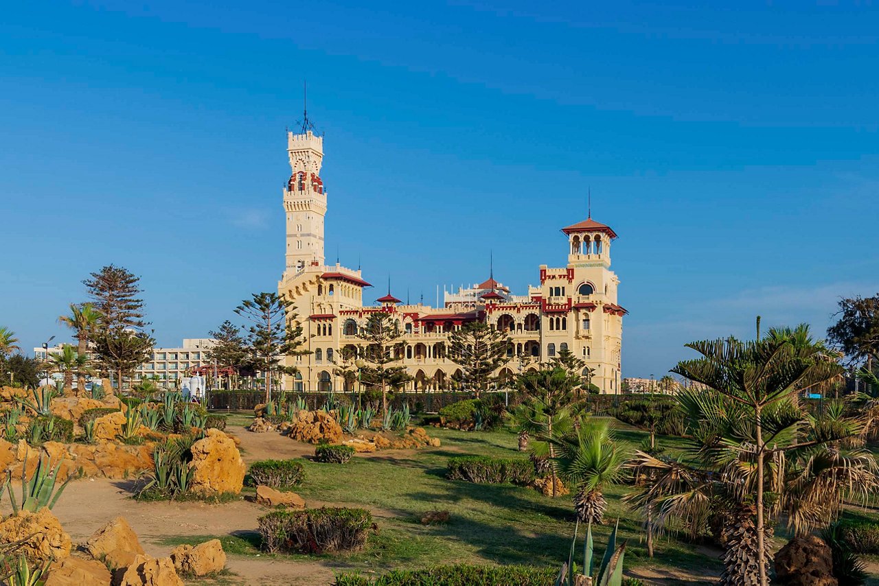 Montaza Palace surrounded by lush gardens and palm trees under a clear blue sky in Alexandria, Egypt | MSC Cruises