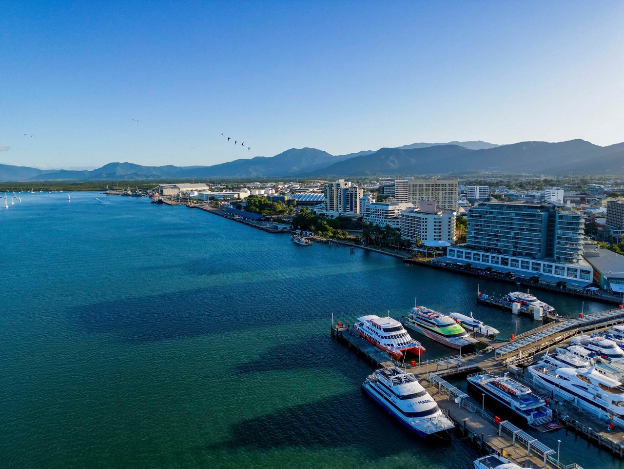 Aerial view of Cairns showcasing the vibrant coastline, mountains, and boats in the serene blue sea | MSC Cruises