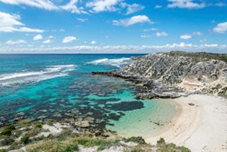 Aerial view of Rottnest Island beach showcasing the stunning blue sea and golden sand against lush vegetation | MSC Cruises