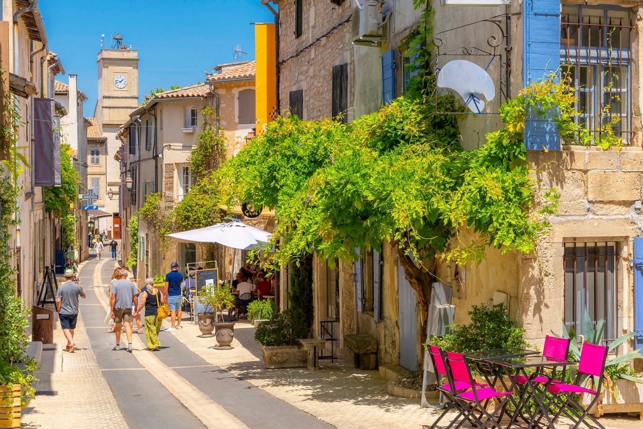 Une rue ensoleillée à Marseille bordée de charmants bâtiments, de verdure et de personnes appréciant l'atmosphère vibrante | MSC Cruises
